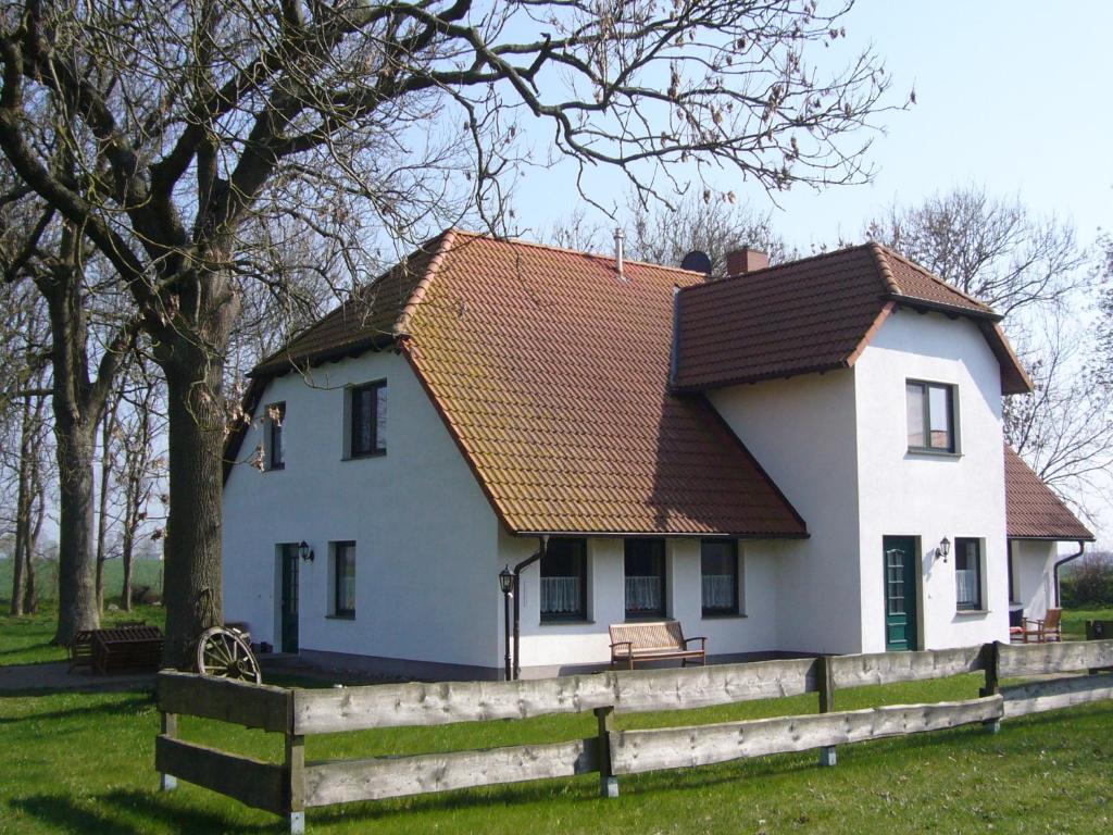 a white house with a brown roof and a fence at Haus Fünfschläfer in Dreschvitz