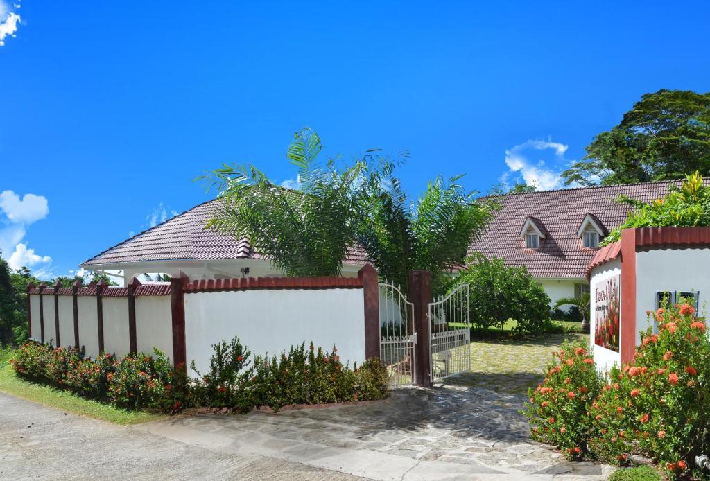 a fence in front of a house at Ixora Villa in Anse Royale