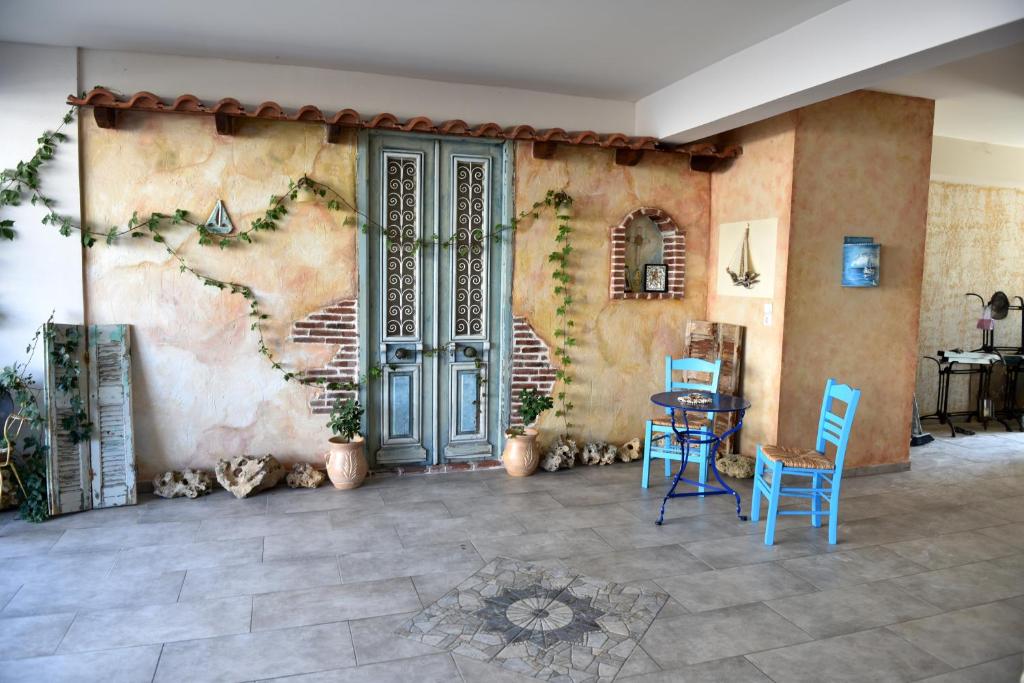 a room with a wall with a door and chairs at Aphrodite studios in Loutra Edipsou