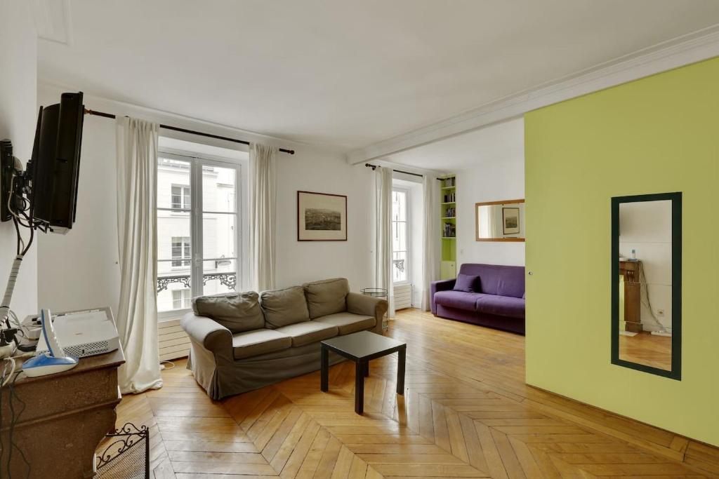 a living room with a couch and a mirror at Unit 009 - Saint Germain des Près (Cherche Midi) in Paris