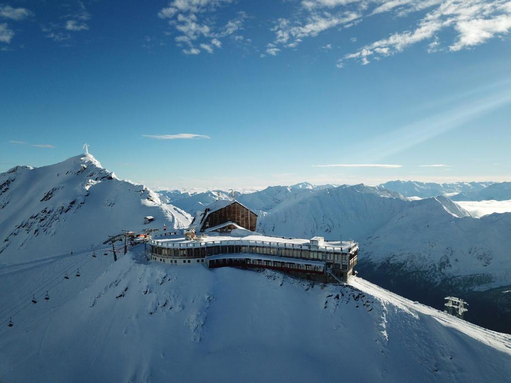 budynek na szczycie pokrytej śniegiem góry w obiekcie Glacier Hotel Grawand w mieście Maso Corto