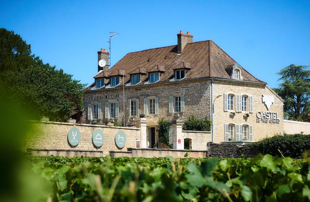 un grand bâtiment en briques avec un toit dans l'établissement Castel de Très Girard - Teritoria, à Morey-Saint-Denis