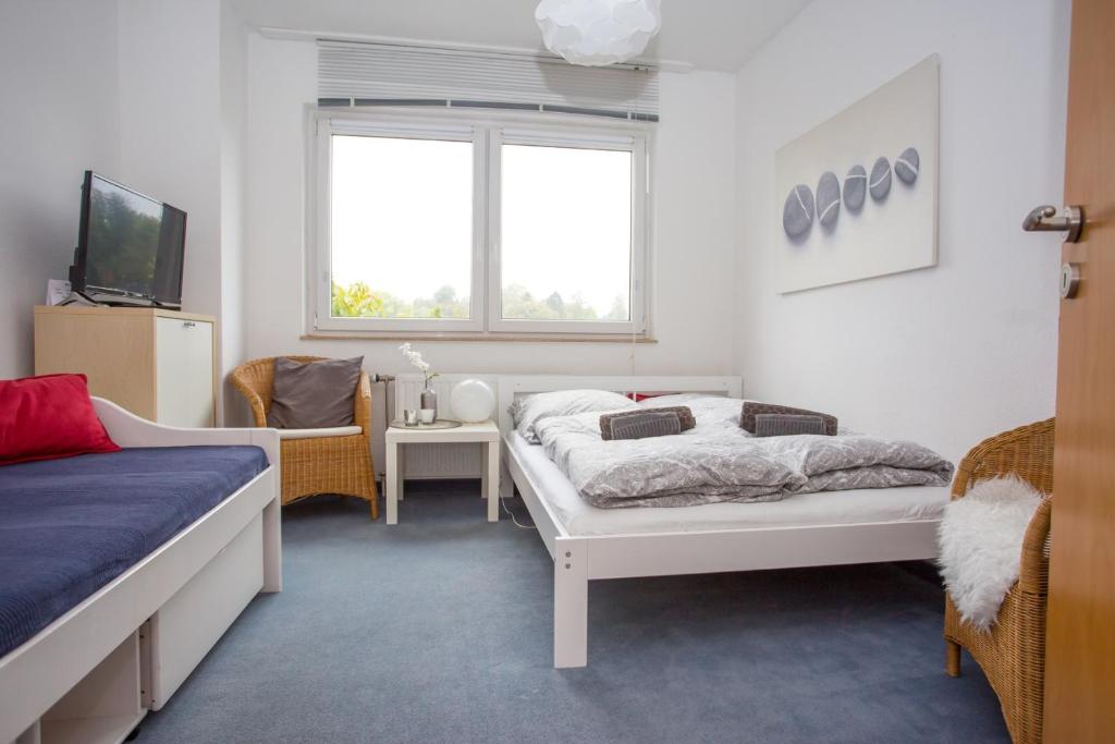 een slaapkamer met 2 bedden, een tv en een raam bij Sweet little Home in Essen