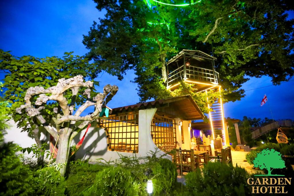 a resort with a tree and a building at Garden Hotel in Kutaisi