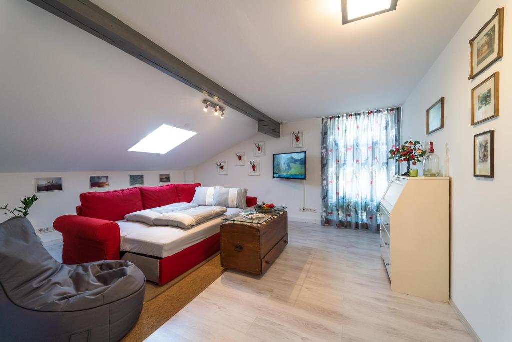 a living room with a red couch and a table at Ferienwohnung EVA in Seekirchen am Wallersee