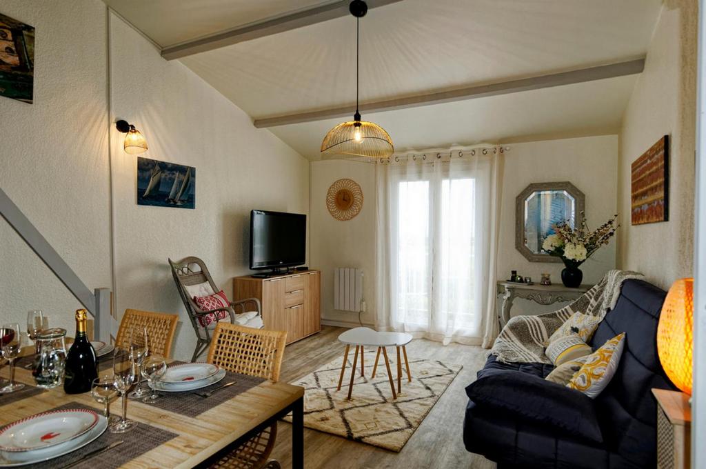 een woonkamer met een bank en een tafel bij Les Coquillages in La Guérinière
