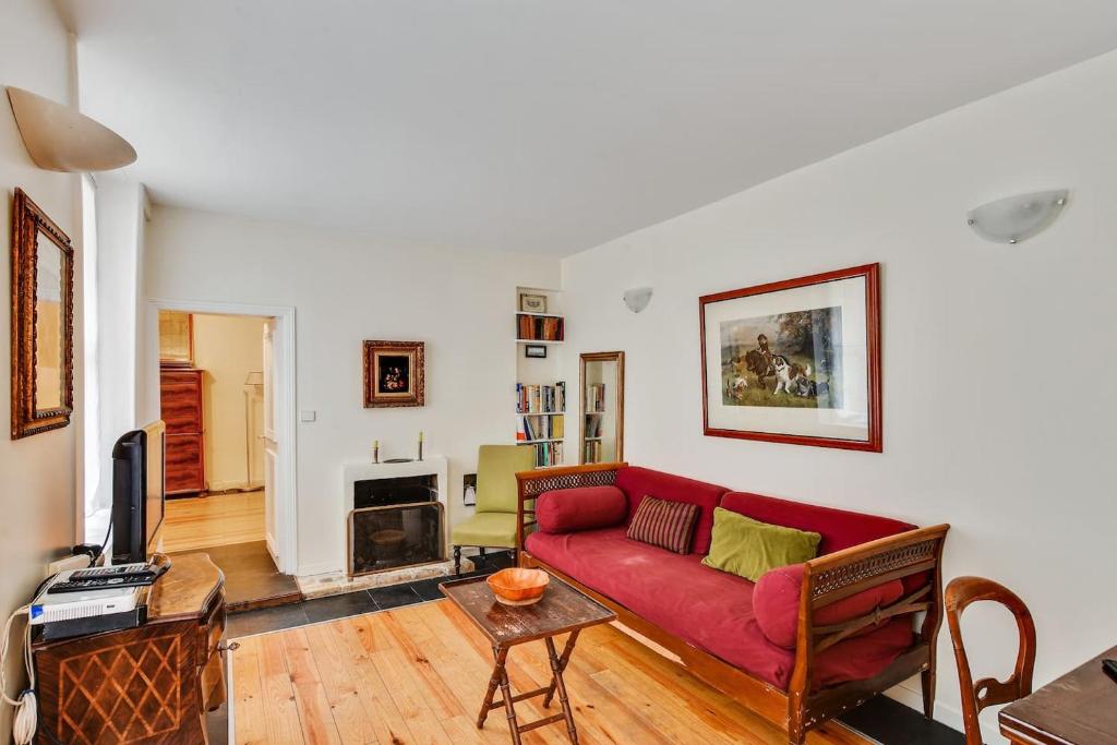 - un salon avec un canapé rouge et une cheminée dans l'établissement Unit 008 Saint Germain des Pres (Bac rdc), à Paris