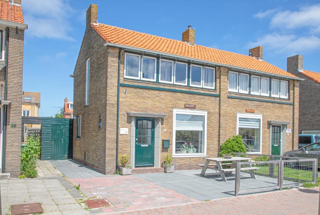 a brick house with a picnic table in front of it at Bosruiter De Koog - Texel in De Koog