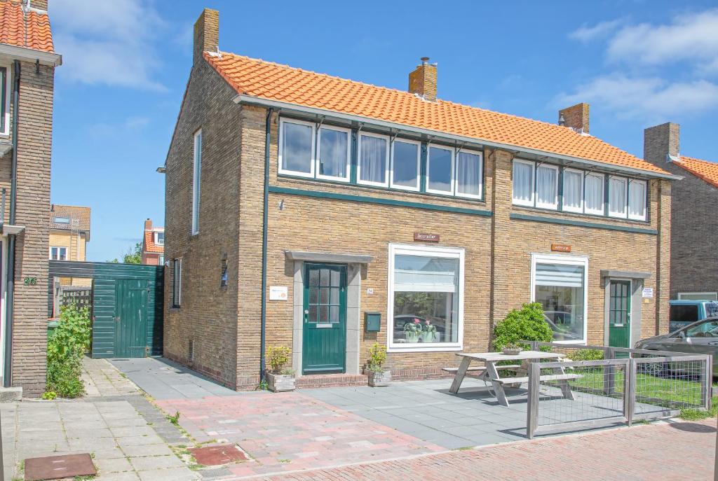 una casa de ladrillo con una mesa de picnic delante de ella en Bosruiter De Koog - Texel, en De Koog