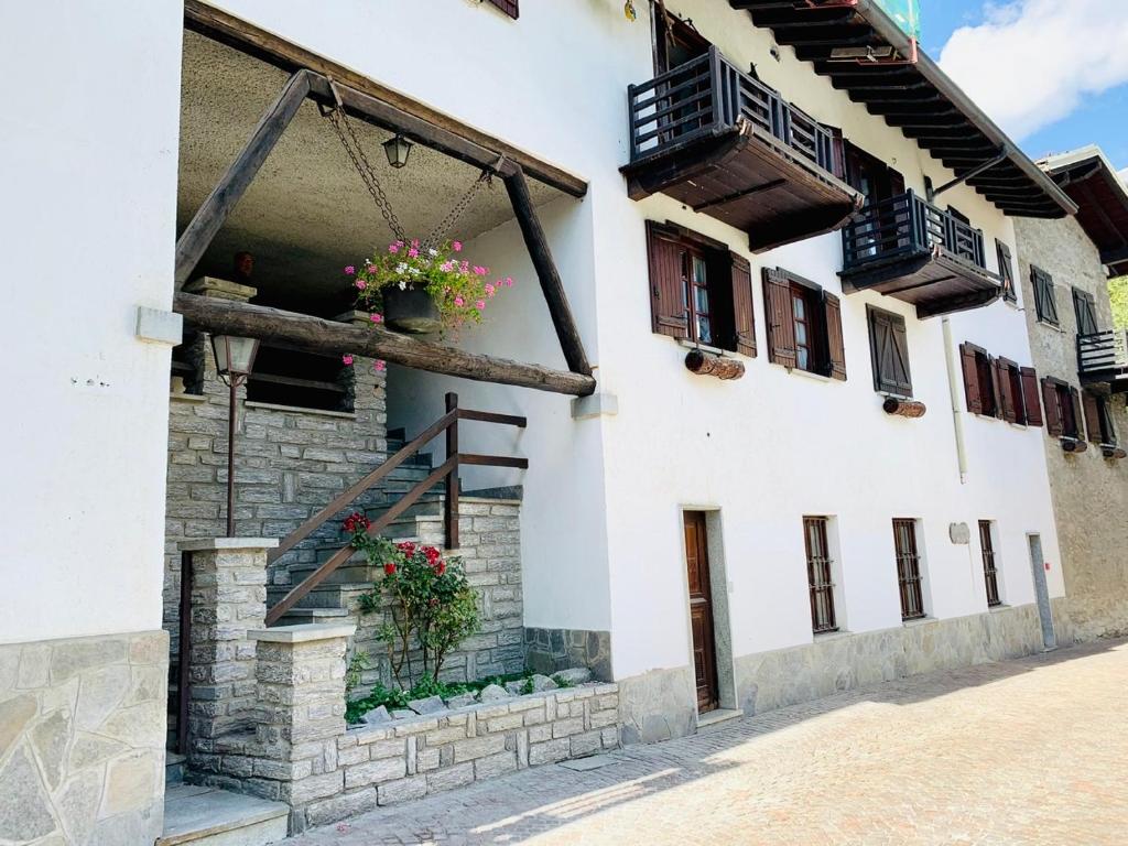 een gebouw met bloempotten aan de zijkant bij Courmayeur La Maison des Amis in Courmayeur