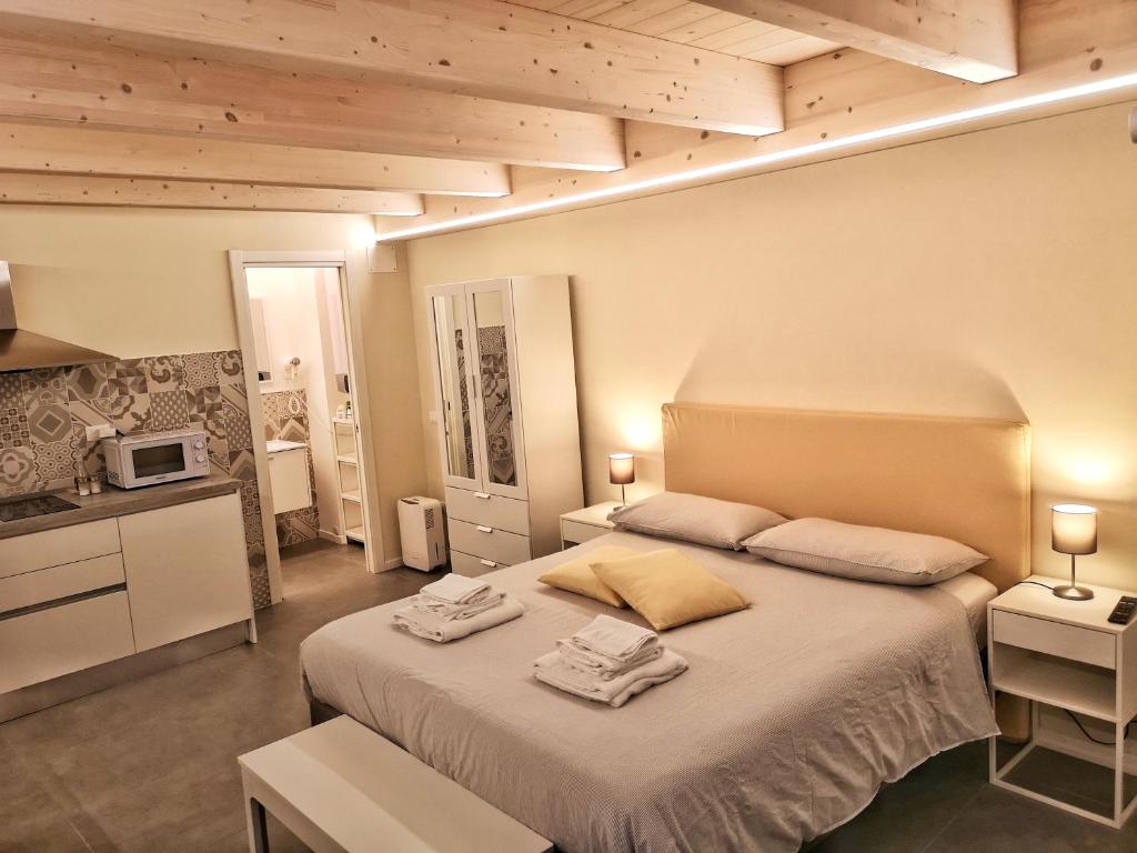 Vico-Letto studio apartment في غواردياغريلي: غرفة نوم بسرير كبير عليها منشفتين
