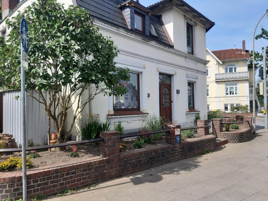 une maison blanche avec un arbre en face dans l'établissement FEWO Gerdi und Hanne, à Schenefeld