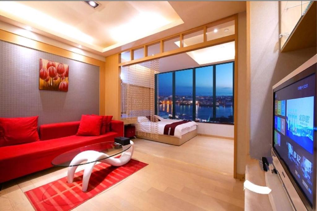 un soggiorno con divano rosso e TV di 85 Cape Inn a Kaohsiung