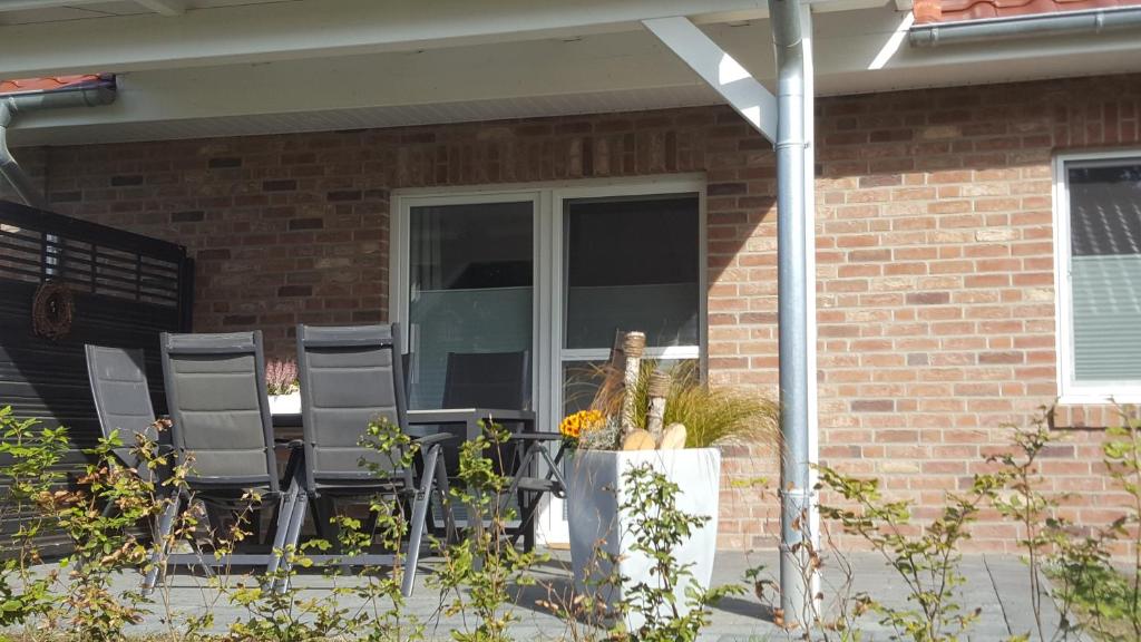 eine Veranda mit Stühlen und ein Fenster zum Haus in der Unterkunft Emsdüne in Oberlangen