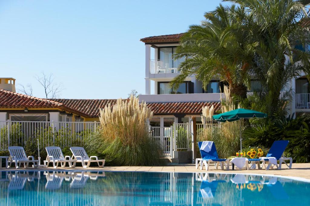 een zwembad met stoelen en een hotel bij SOWELL Family Port Grimaud in Grimaud