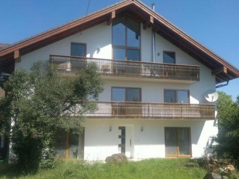 a large white building with a balcony on it at Ferienwohnung Kaps in Aying