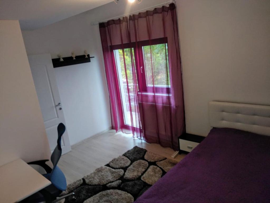 1 dormitorio con puerta morada, cama y silla en Anastasia's Villa, en Iaşi