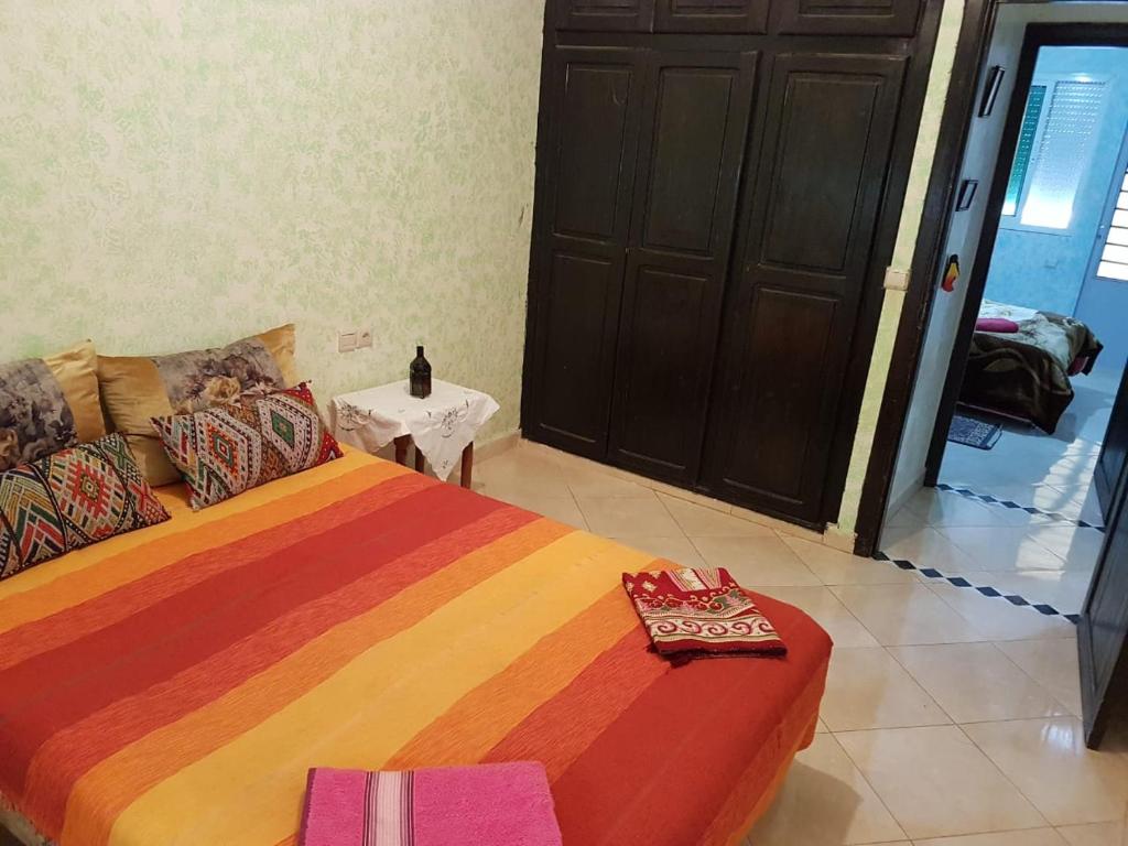 um quarto com uma cama grande e um cobertor colorido em Joli Appartement Meublé à Rte Ain Chkef em Fez