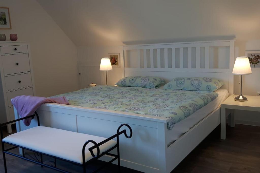 ein weißes Bett in einem Schlafzimmer mit zwei Lampen in der Unterkunft Ferienwohnung an der Südheide 80 qm max 4 Personen in Dedelstorf