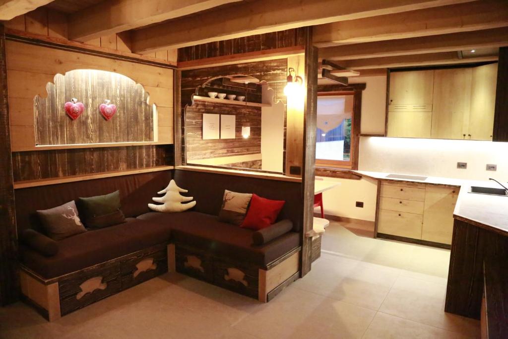 a living room with a couch in a kitchen at Chalet Al Cucù in Ovaro