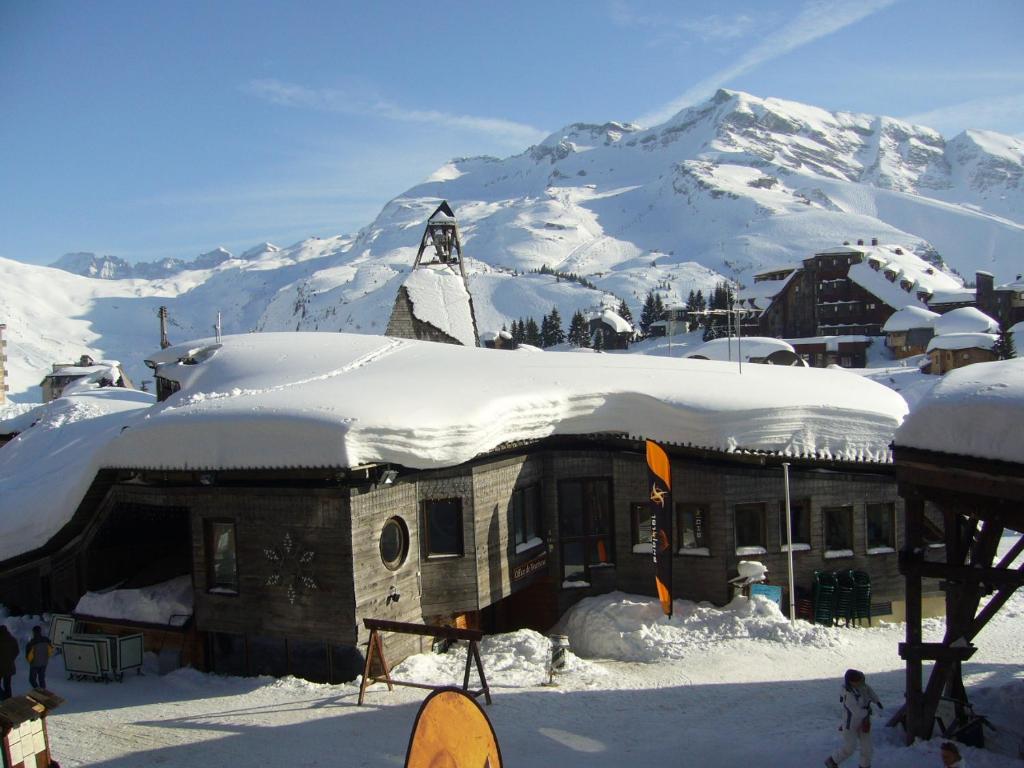 a building covered in snow with a mountain in the background at Fontaines Blanches 320 in Avoriaz