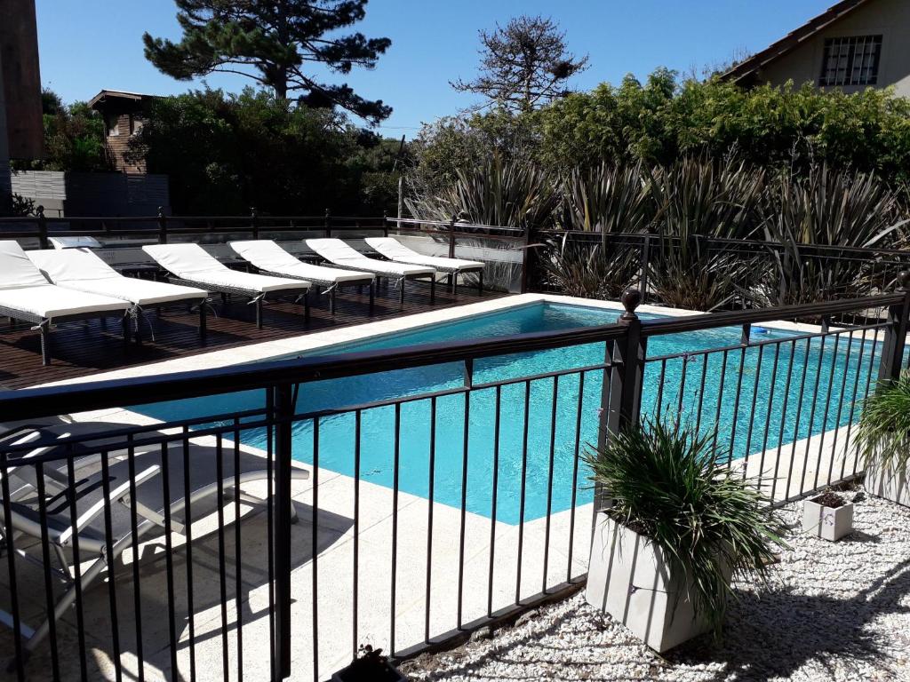 オステンデにあるAyres del Esteの椅子とフェンスのあるプール