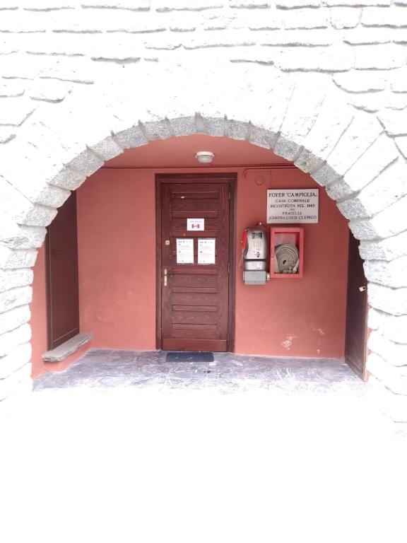 an entrance to a building with a red door at PHOENIX HOSTEL in Valprato Soana