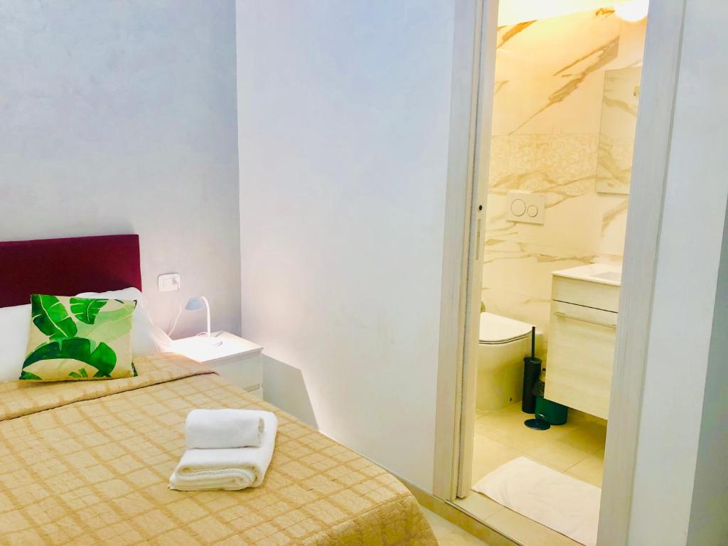 Dormitorio pequeño con cama y espejo en ABID'S PALACE IN TERMINI en Roma