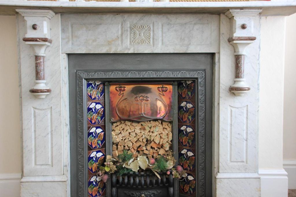 a fireplace with a painting on top of it at Candlelight in Minehead