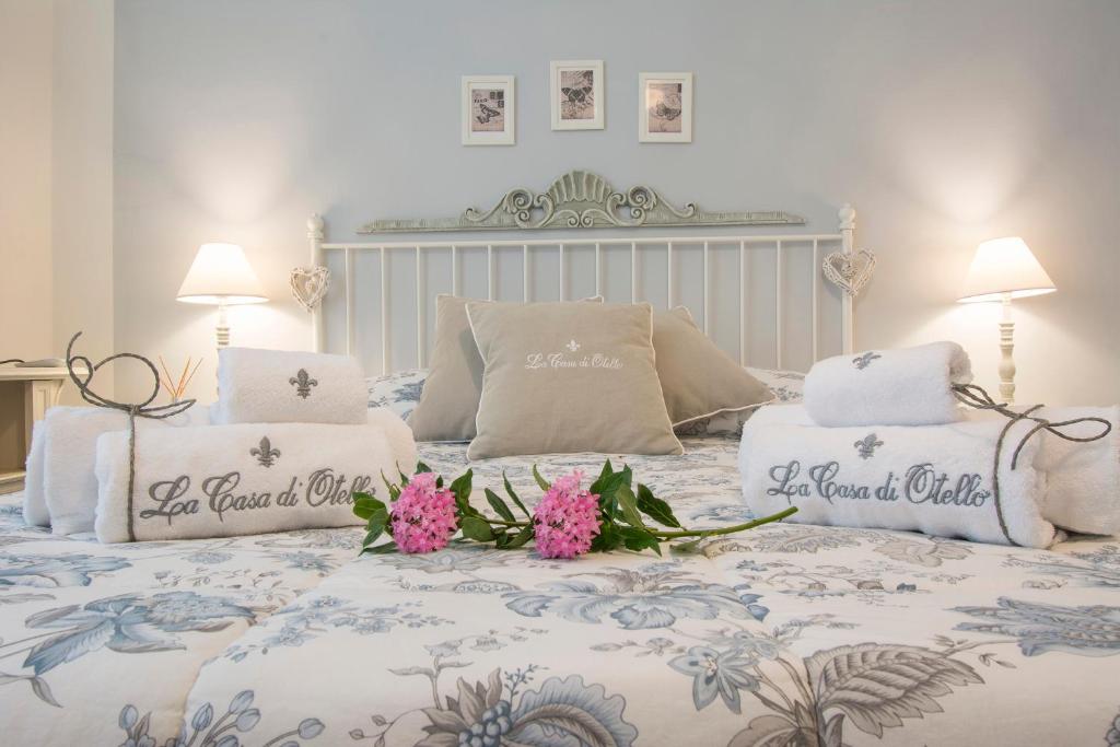 łóżko z dwoma poduszkami i kwiatami w obiekcie B&B La Casa di Otello w mieście Carmignano