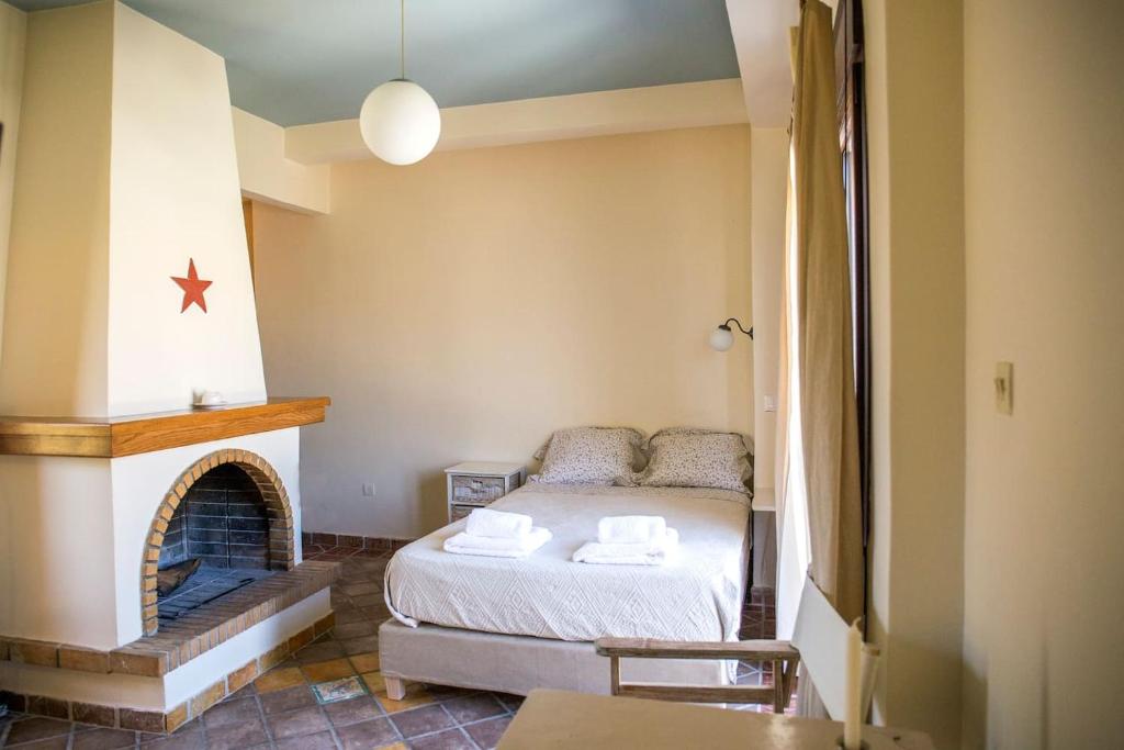 een kleine slaapkamer met een bed en een open haard bij Sunny Top Floor Studio - Excellent Athens view in Athene