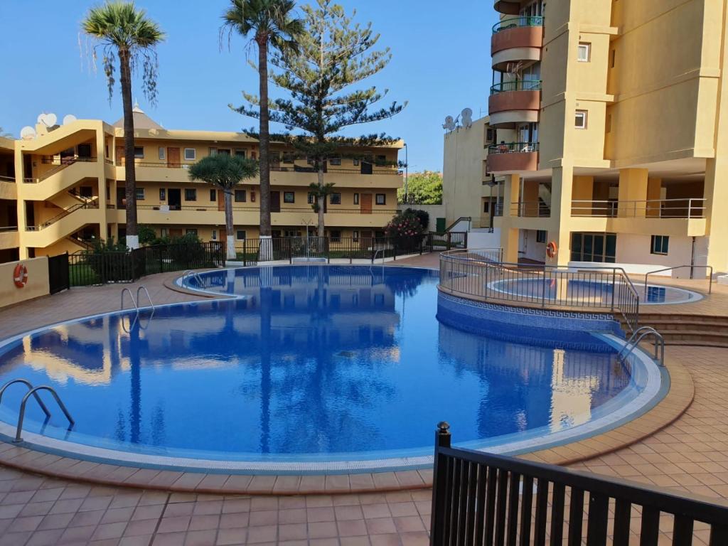 une grande piscine devant certains immeubles d'habitation dans l'établissement Apartamento Torres del Sol, à Arona