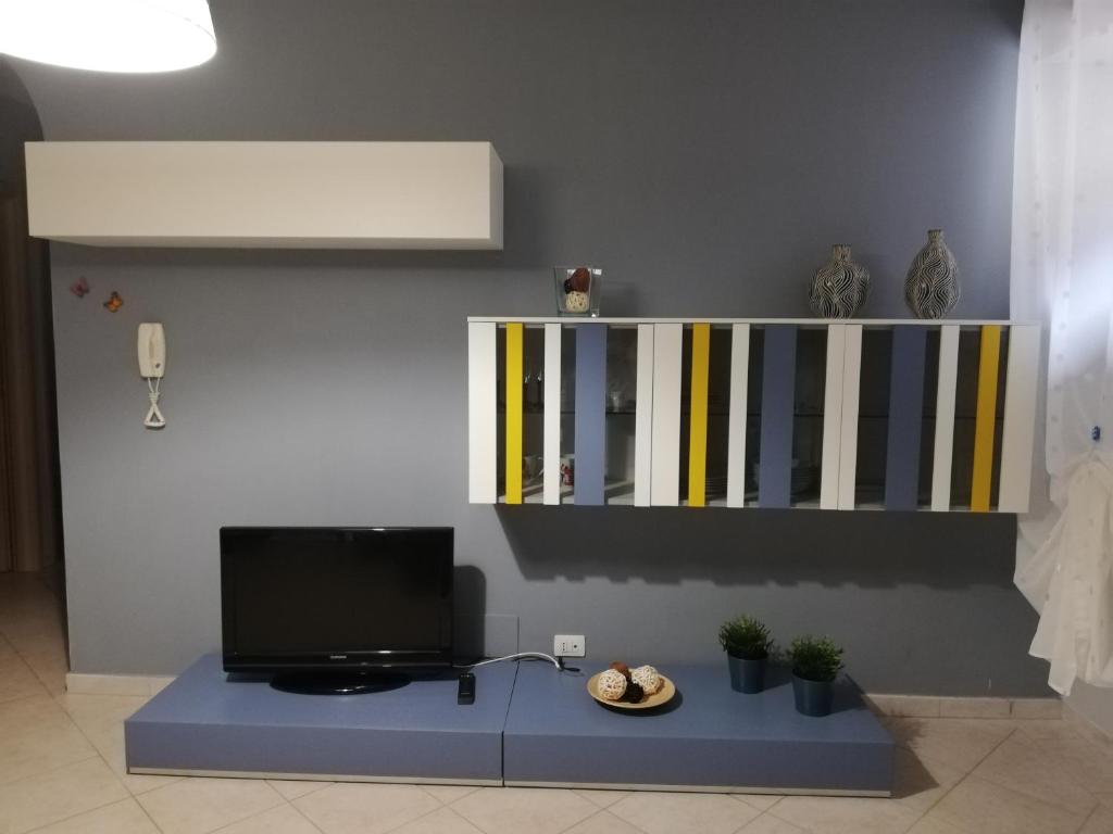 Anchida casa vacanze في إينّا: غرفة معيشة مع تلفزيون ورف
