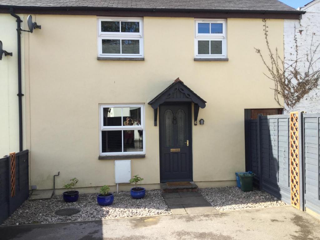 a house with a black door and windows at 6 beili priory in Abergavenny