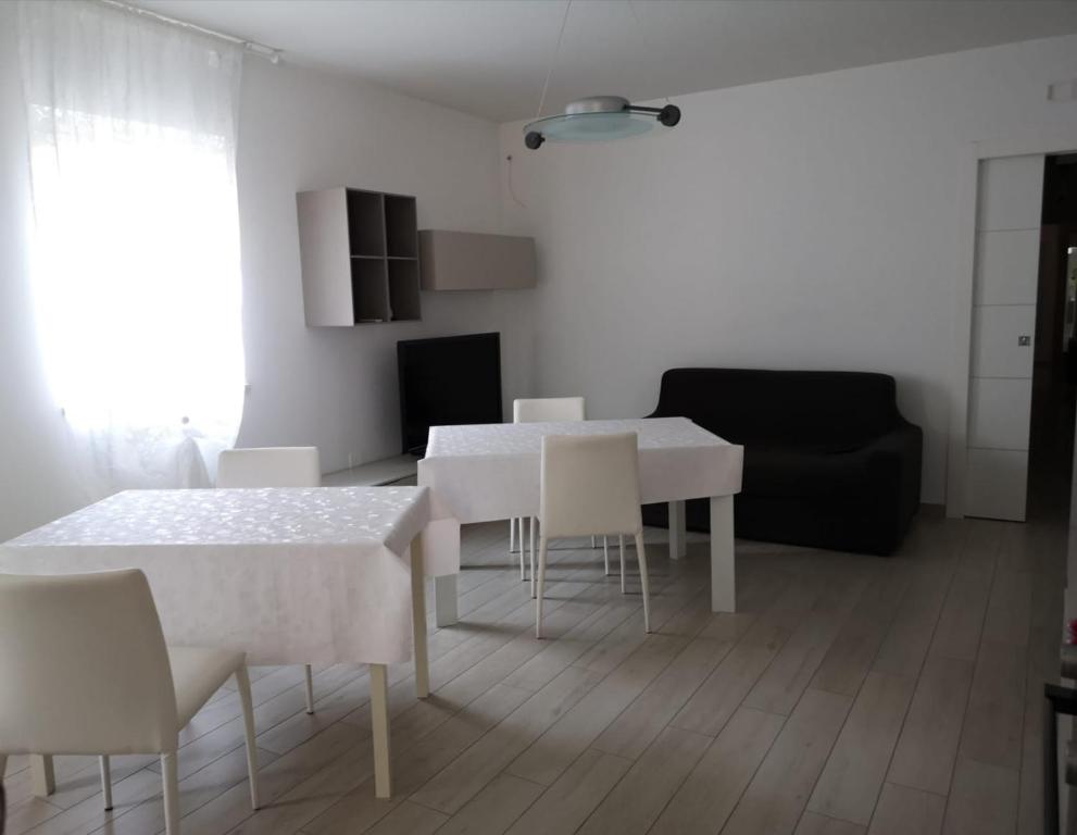 ein Wohnzimmer mit einem weißen Tisch und Stühlen in der Unterkunft La Passione Dei Sassi in Matera