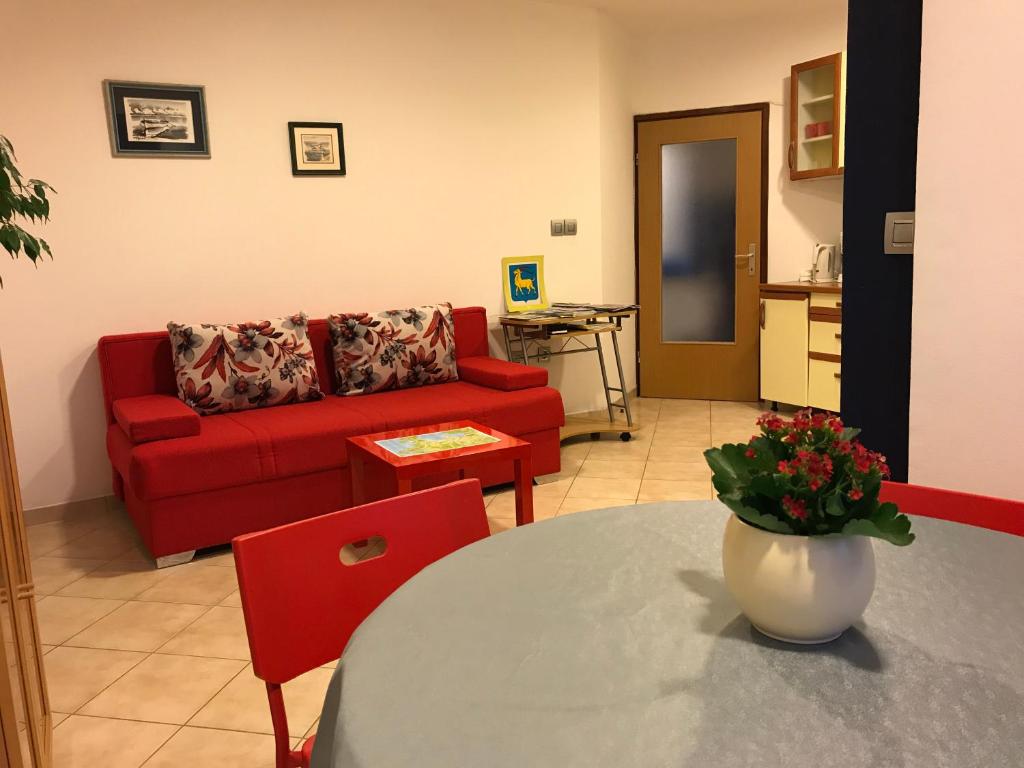 a living room with a red couch and a table at Apartment Pula Center with private parking in Pula