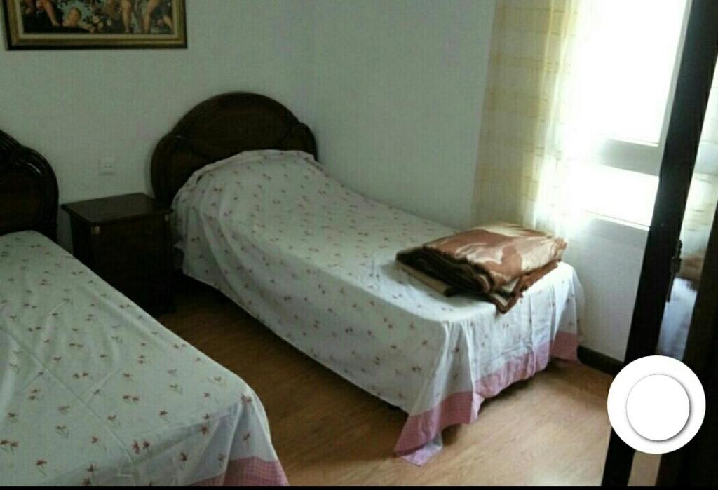 niewielka sypialnia z 2 łóżkami i oknem w obiekcie habitacion w mieście Gijón