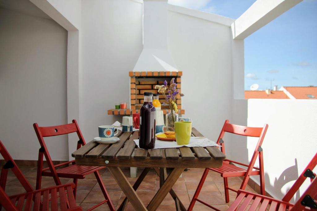 Vila Mafra - Grill Terrace في مافرا: طاولة مع كراسي وزجاجة من النبيذ عليها