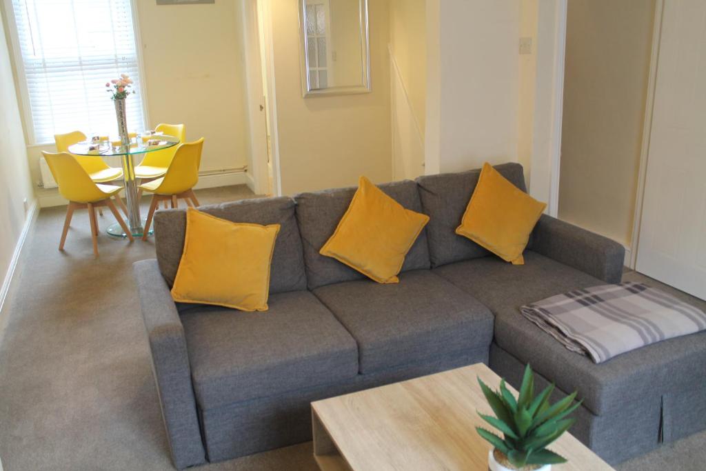 a living room with a gray couch with yellow pillows at Salisbury Solace in Salisbury