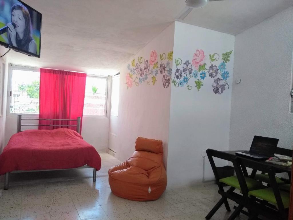 a bedroom with a bed and a chair and a table at Habitación privada en Casa Mestiza in Mérida