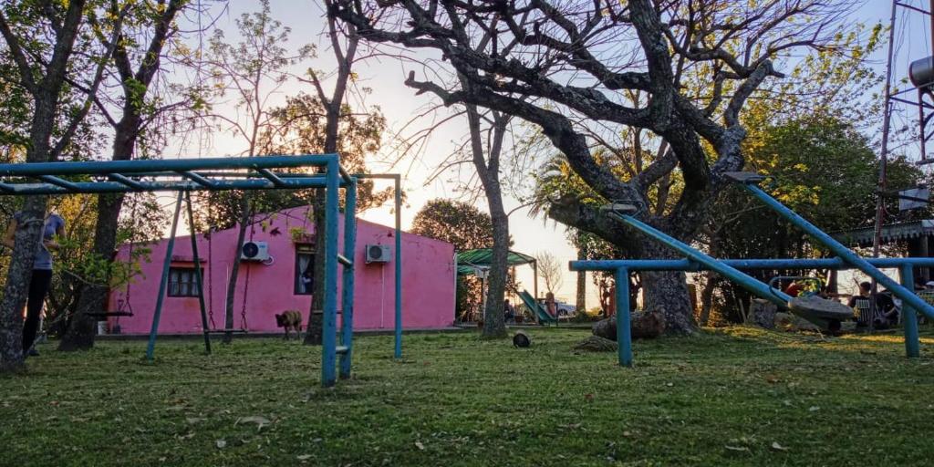 a playground in front of a pink house at Solar de Campo in Villa Elisa