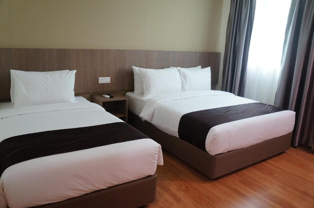Postel nebo postele na pokoji v ubytování LABUAN JATI HOTEL