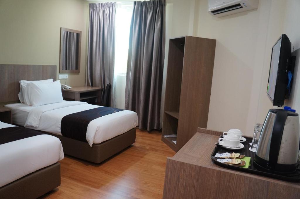 Postel nebo postele na pokoji v ubytování LABUAN JATI HOTEL