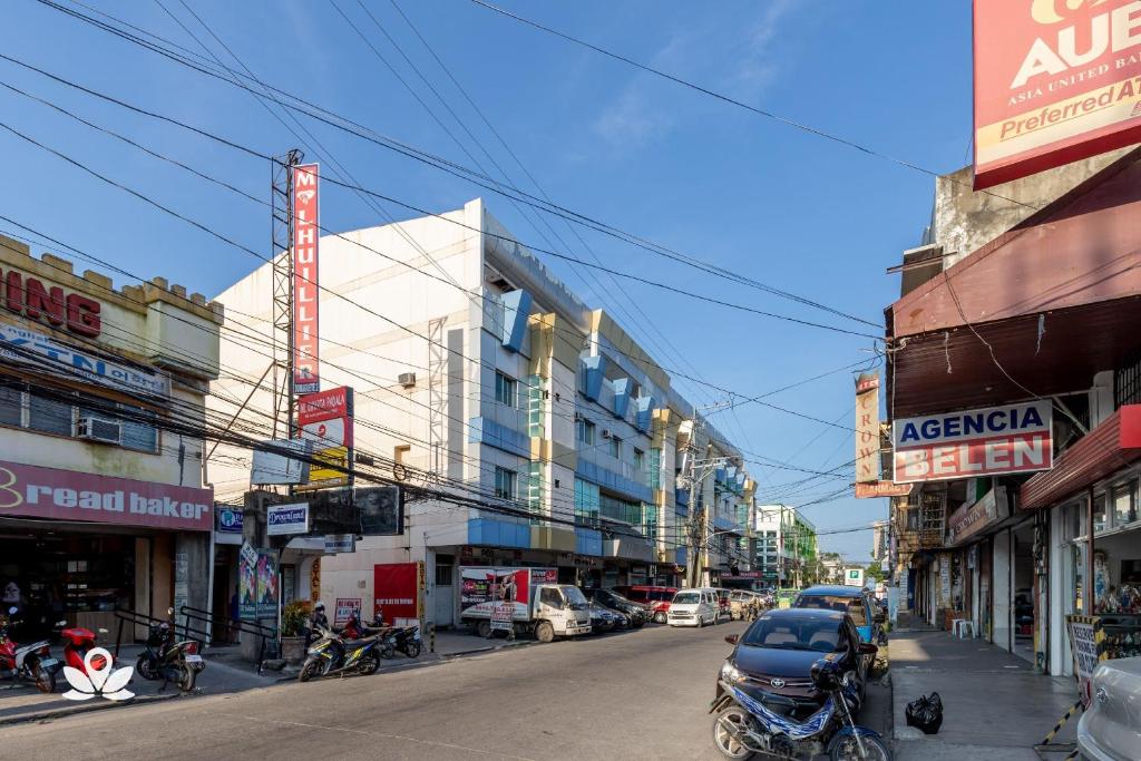 a busy city street with buildings and cars on the road at Check Inn Hotel Dumaguete City by RedDoorz in Dumaguete