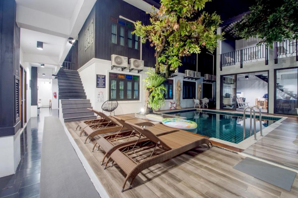 a house with a swimming pool and lounge chairs at Sathu Hotel in Chiang Mai