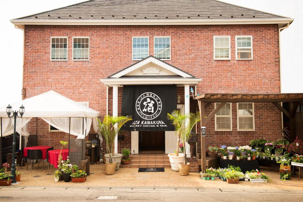 a red brick building with a black sign on it at IZA Kamakura Guest House and Bar in Kamakura