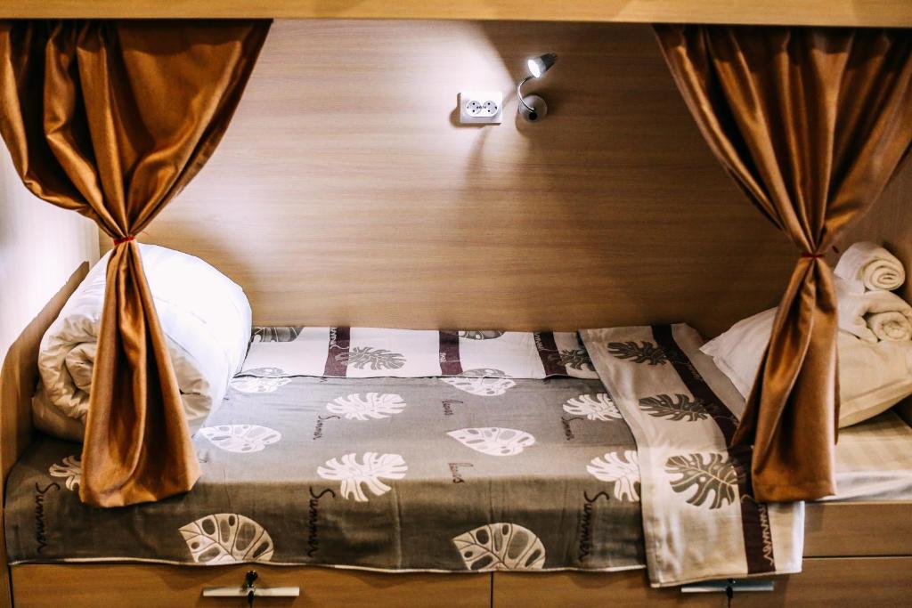 um quarto com uma cama com uma cortina em Good Hostel em Vladivostok