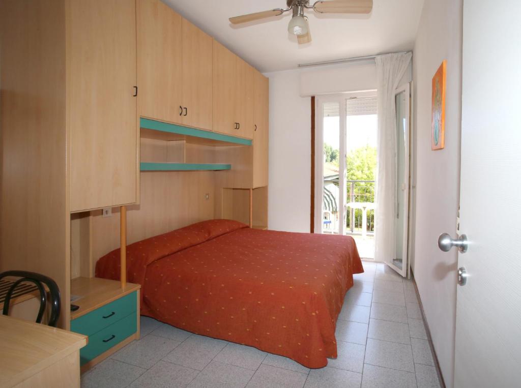 1 dormitorio con 1 cama con colcha roja en Hotel Roby, en Lido di Jesolo