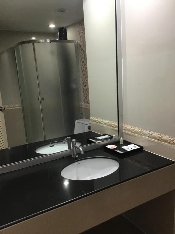a bathroom with two sinks and a large mirror at Tonkoon Hotel in Udon Thani