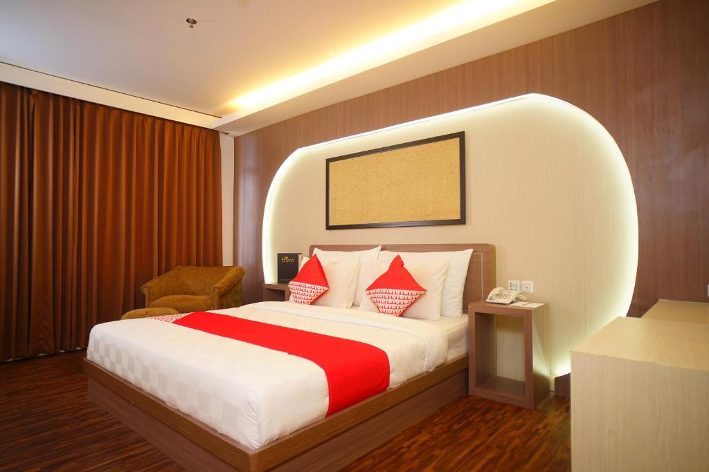 Habitación de hotel con cama con almohadas rojas y blancas en SUPER OYO Collection O 166 Hotel Princess, en Palembang